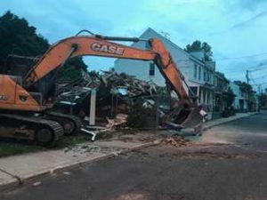 a large crane cleaning up debris from a demolition job