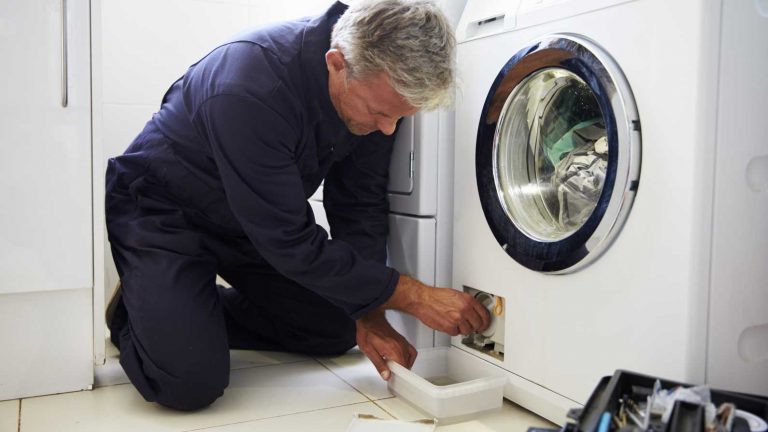 technician fixing leaking washing machine