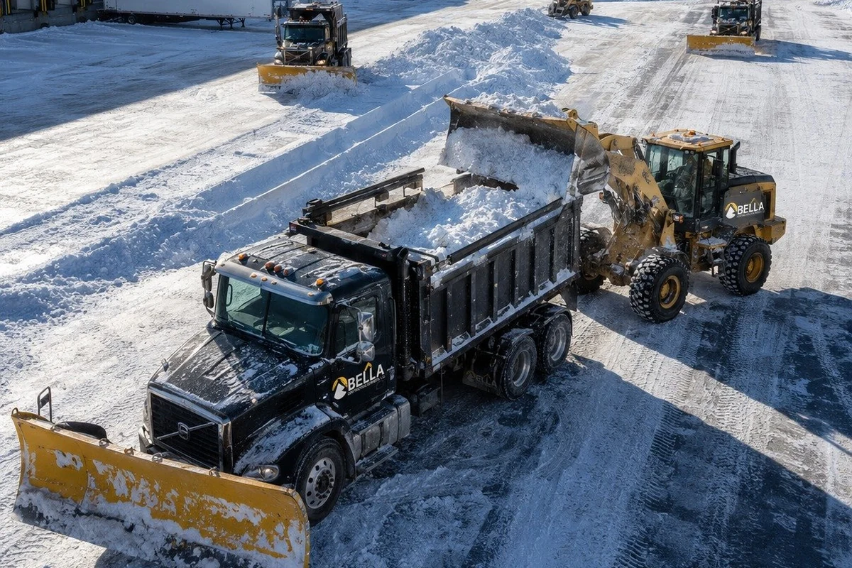Snow removal trucks clearing a lot