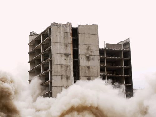 Old building demolition by controlled implosion using explosives.